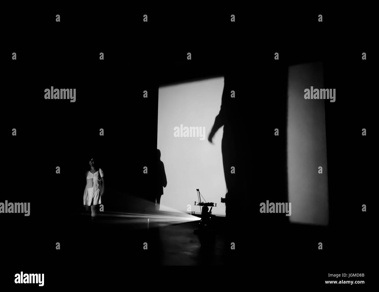 Femme debout dans le chemin d'une lumière projetée dans un musée d'art Banque D'Images