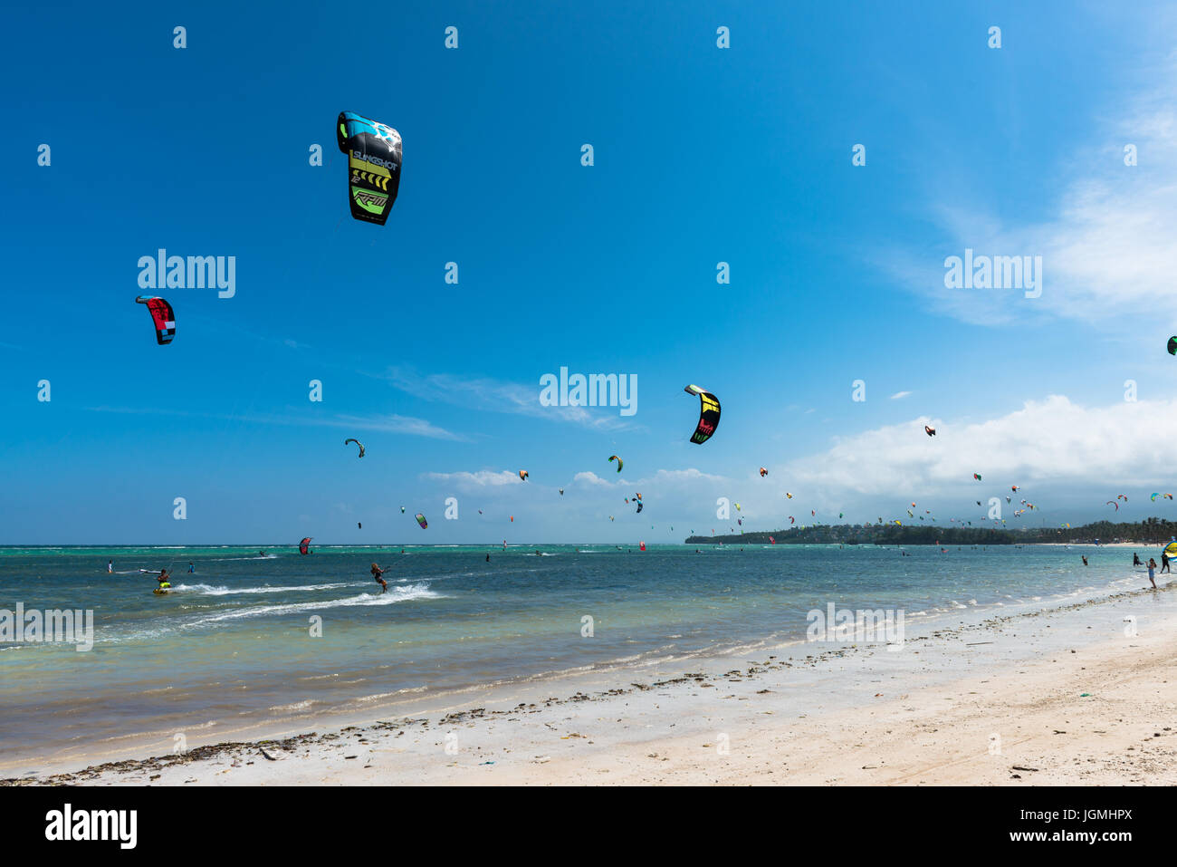 Ciel bleu avec des personnes faisant le kitesurf et planche à voile au cours de l'heure d'été à Bulabog Plage. Banque D'Images