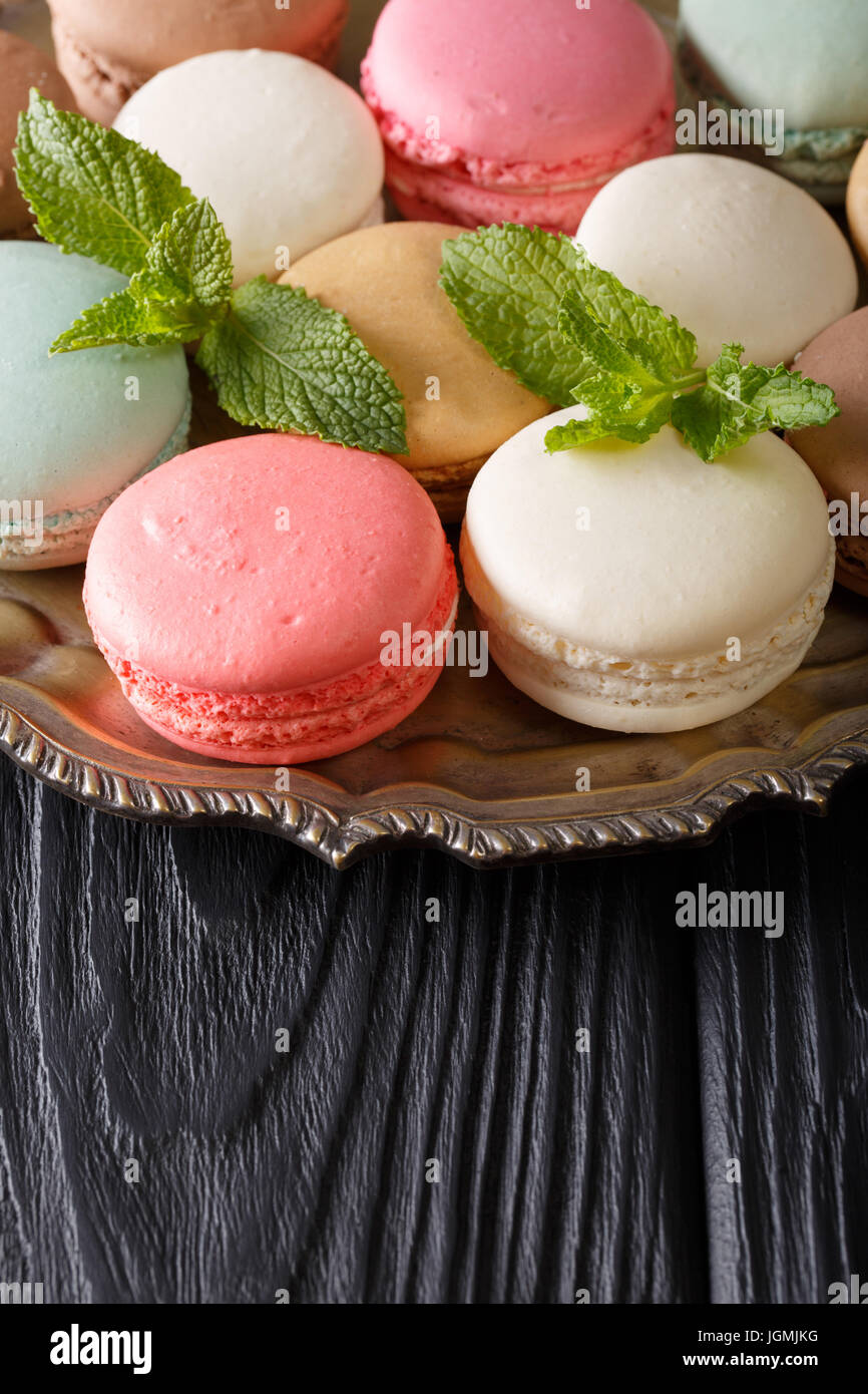 Blanc, rose et menthe macaronis close-up sur un plateau sur la table verticale. Banque D'Images