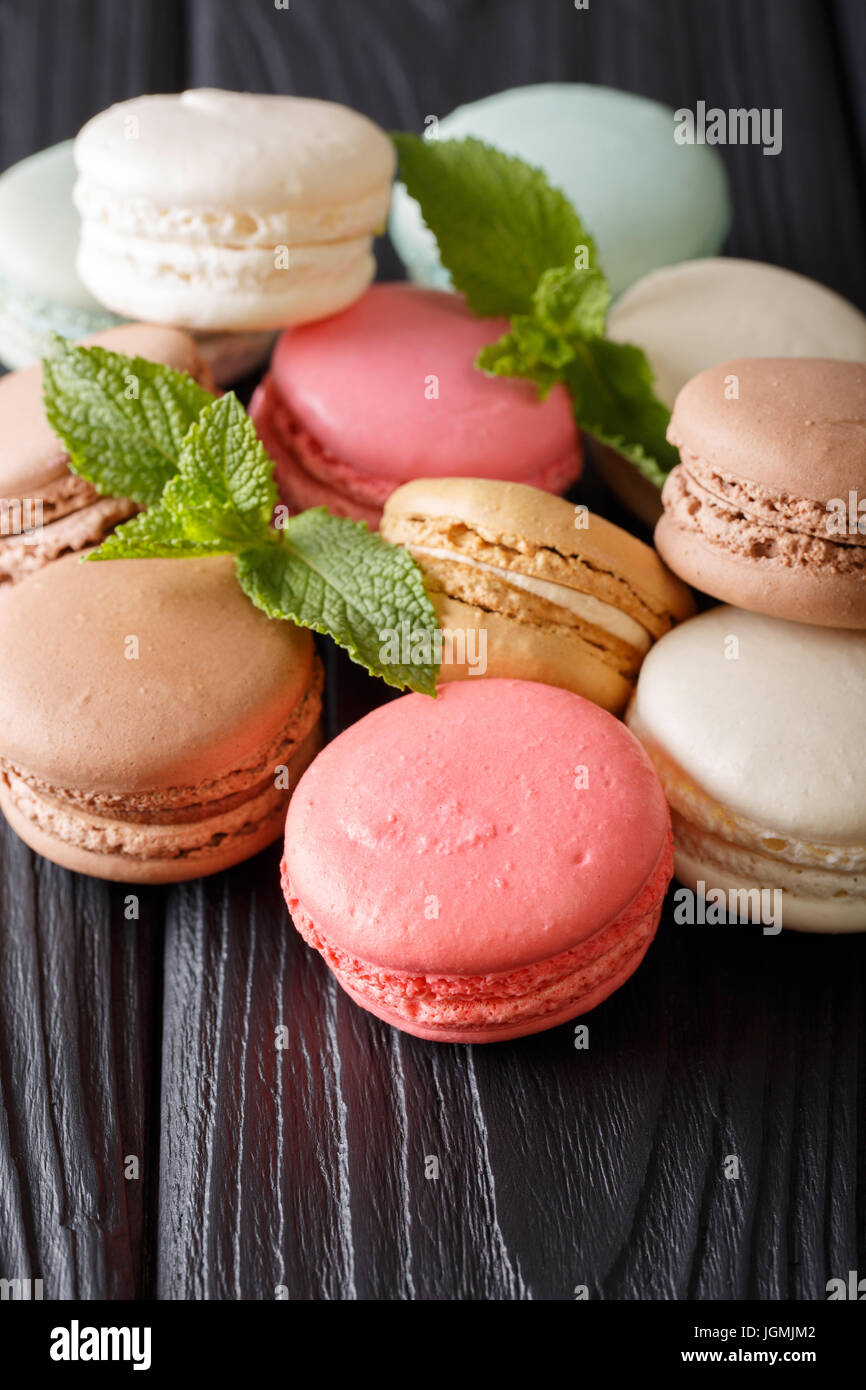 Macarons multicolores et de menthe fraîche gros plan sur une table. La verticale Banque D'Images