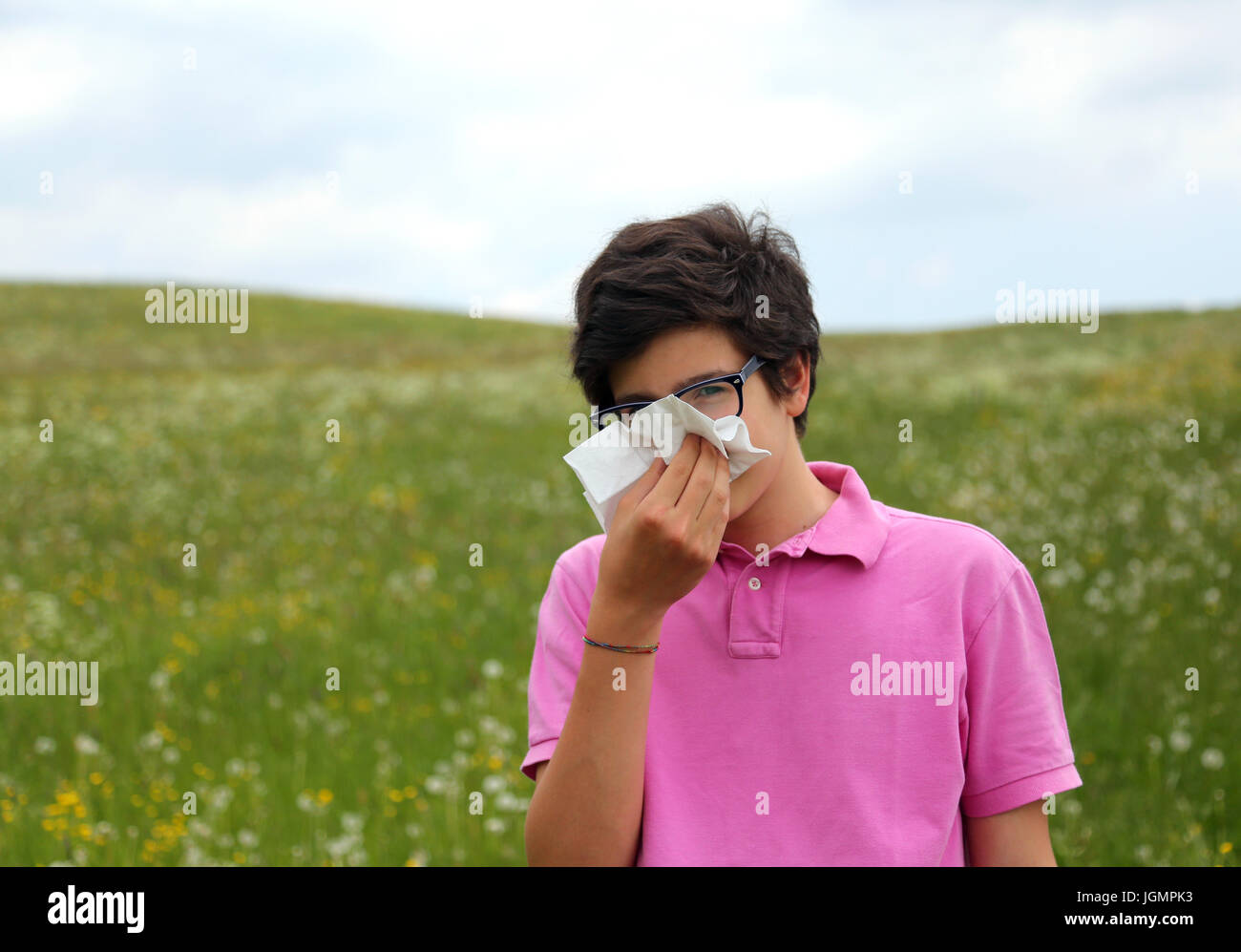 Garçon allergique avec des lunettes ses coups de nez par mouchoir blanc au  printemps Photo Stock - Alamy
