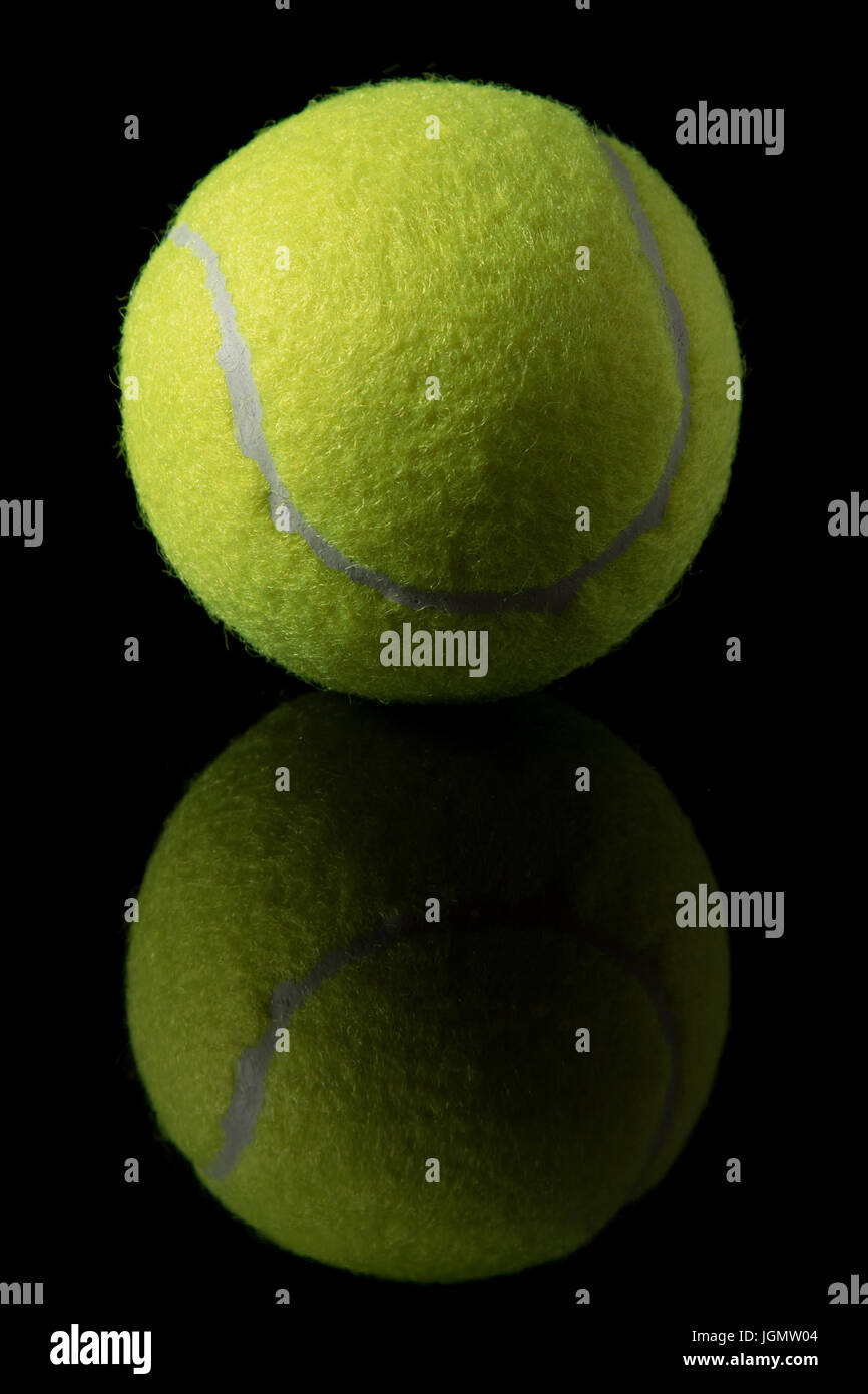 Une seule balle de tennis isolé sur un fond noir Banque D'Images