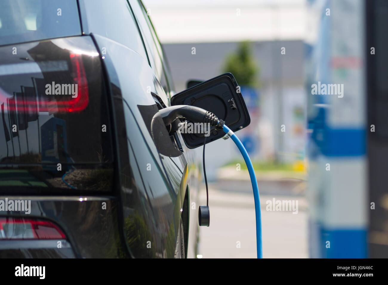 Bloc d'alimentation branché sur une voiture électrique en cours de charge. Banque D'Images