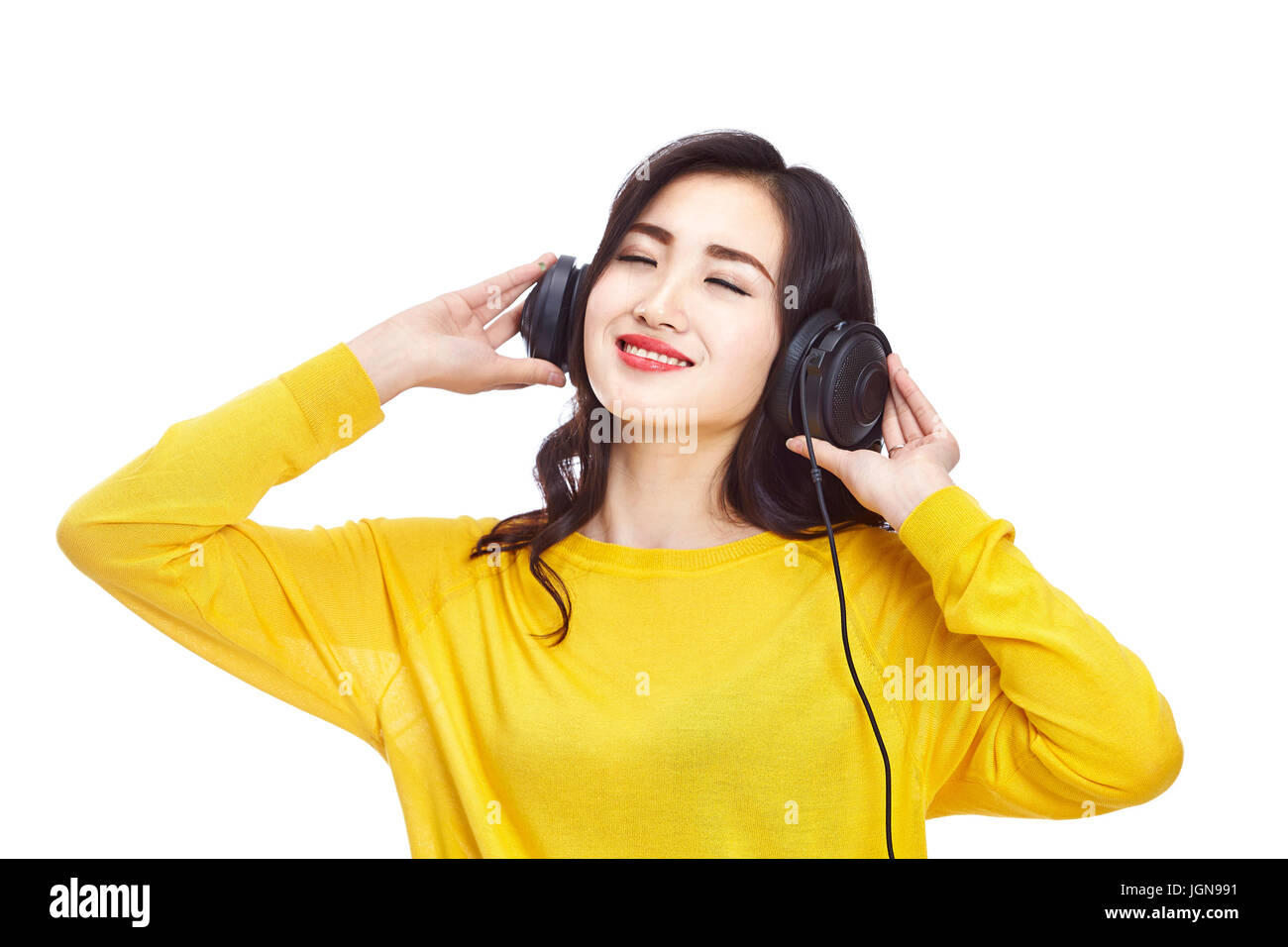 Young Asian woman enjoying music avec casque, isolé sur fond blanc. Banque D'Images