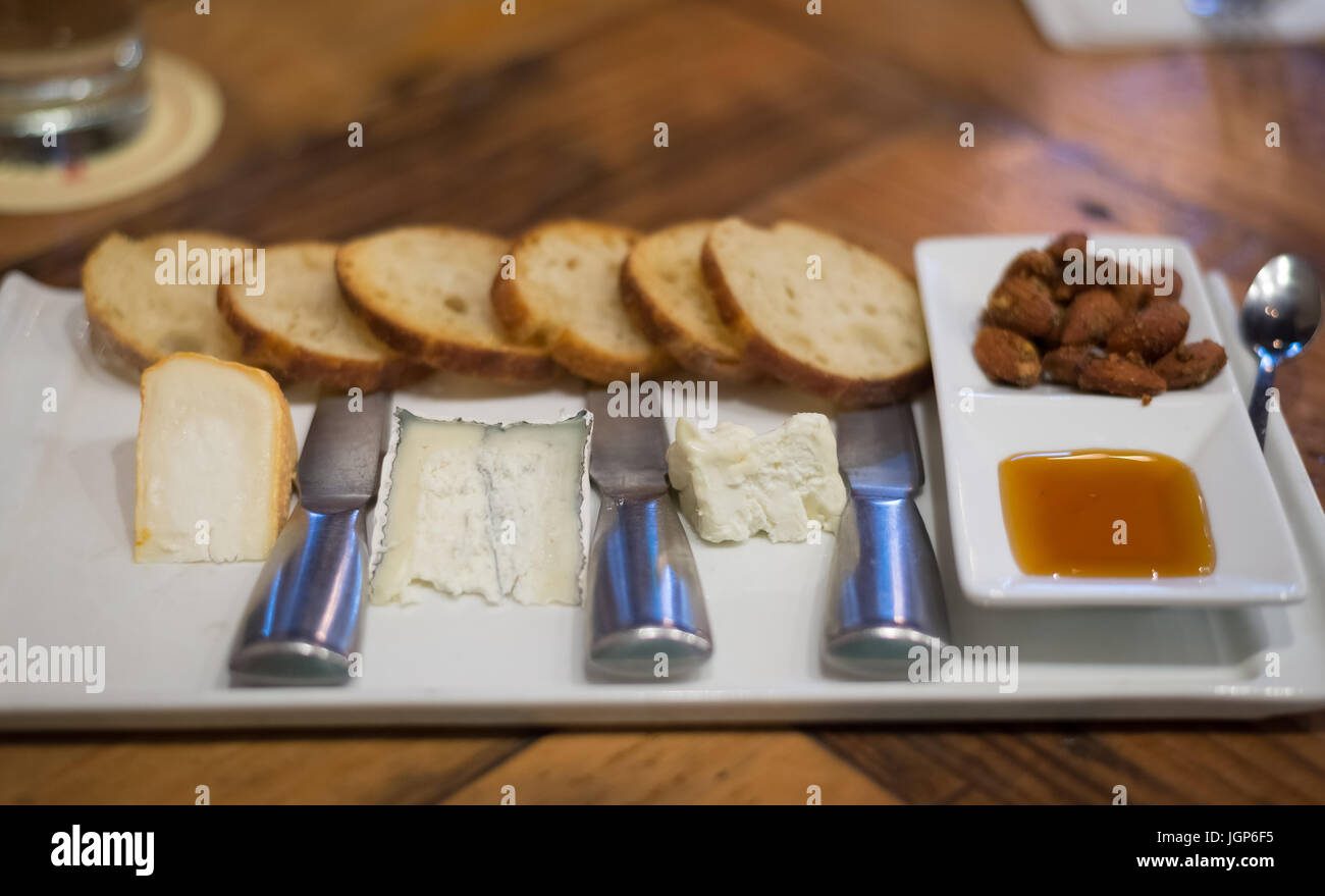 Assiette de fromage avec trois types de fromage, amandes, miel et Banque D'Images
