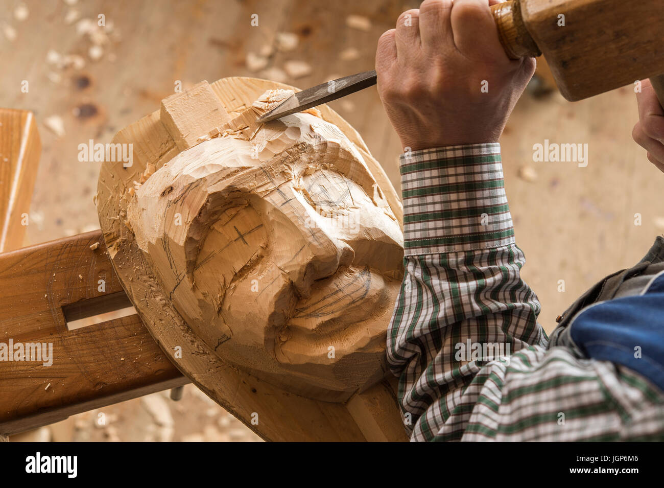 Sculpter le visage d'un masque en bois en bloc en bois à l'aide d