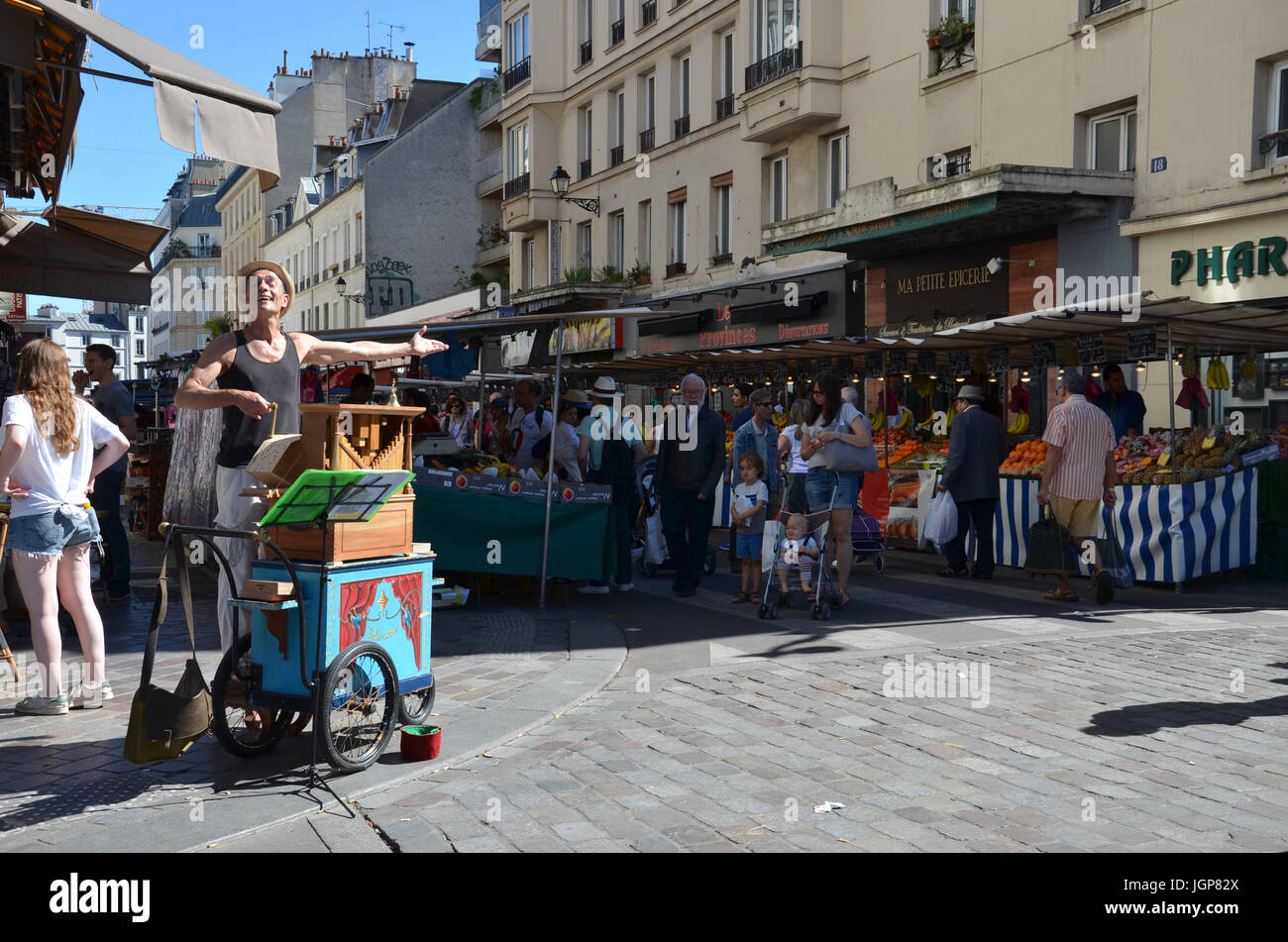 PARIS - 7 août : une rue organiste joue un orgue mécanique à la Marche d'Aligre à Paris, France le 7 août 2016. L'orgue joue des feuilles pliées de Banque D'Images