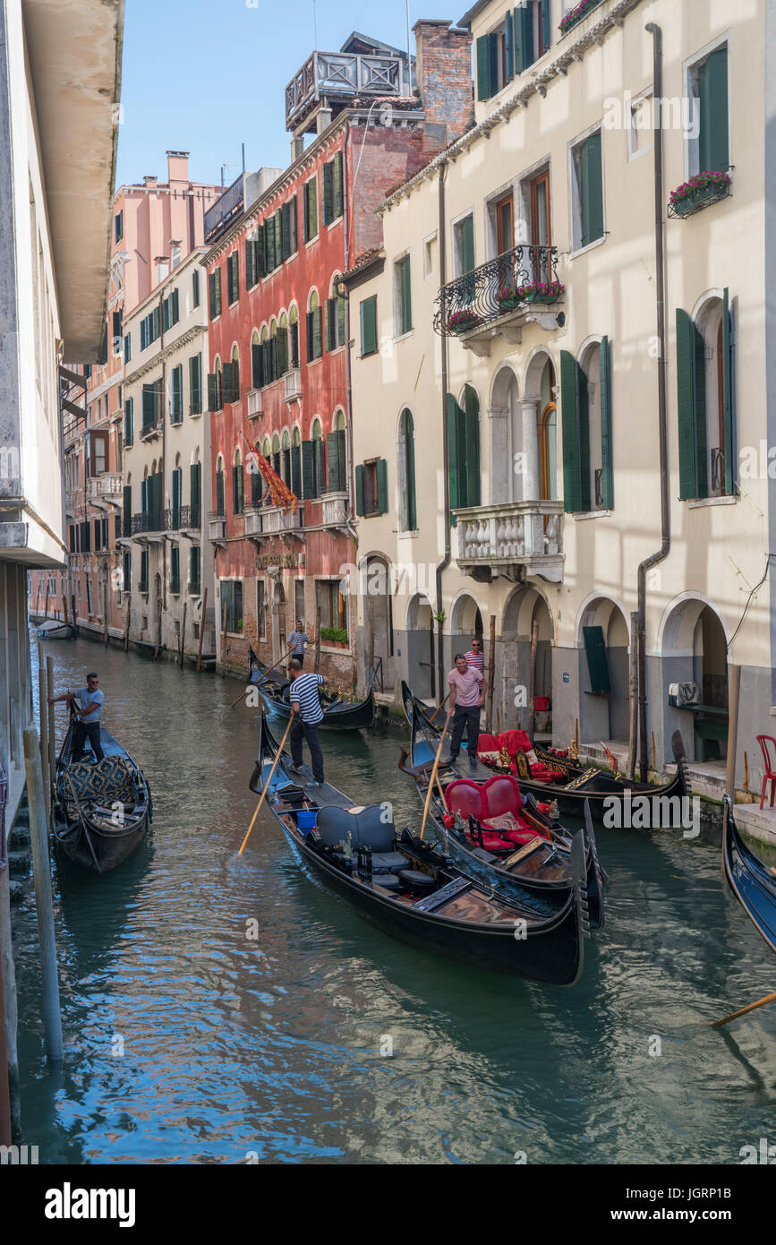 Venise, Italie - 1 juillet 2016 : Gondoliers naviguer à travers un canal gondoles à Venise, Italie. Banque D'Images