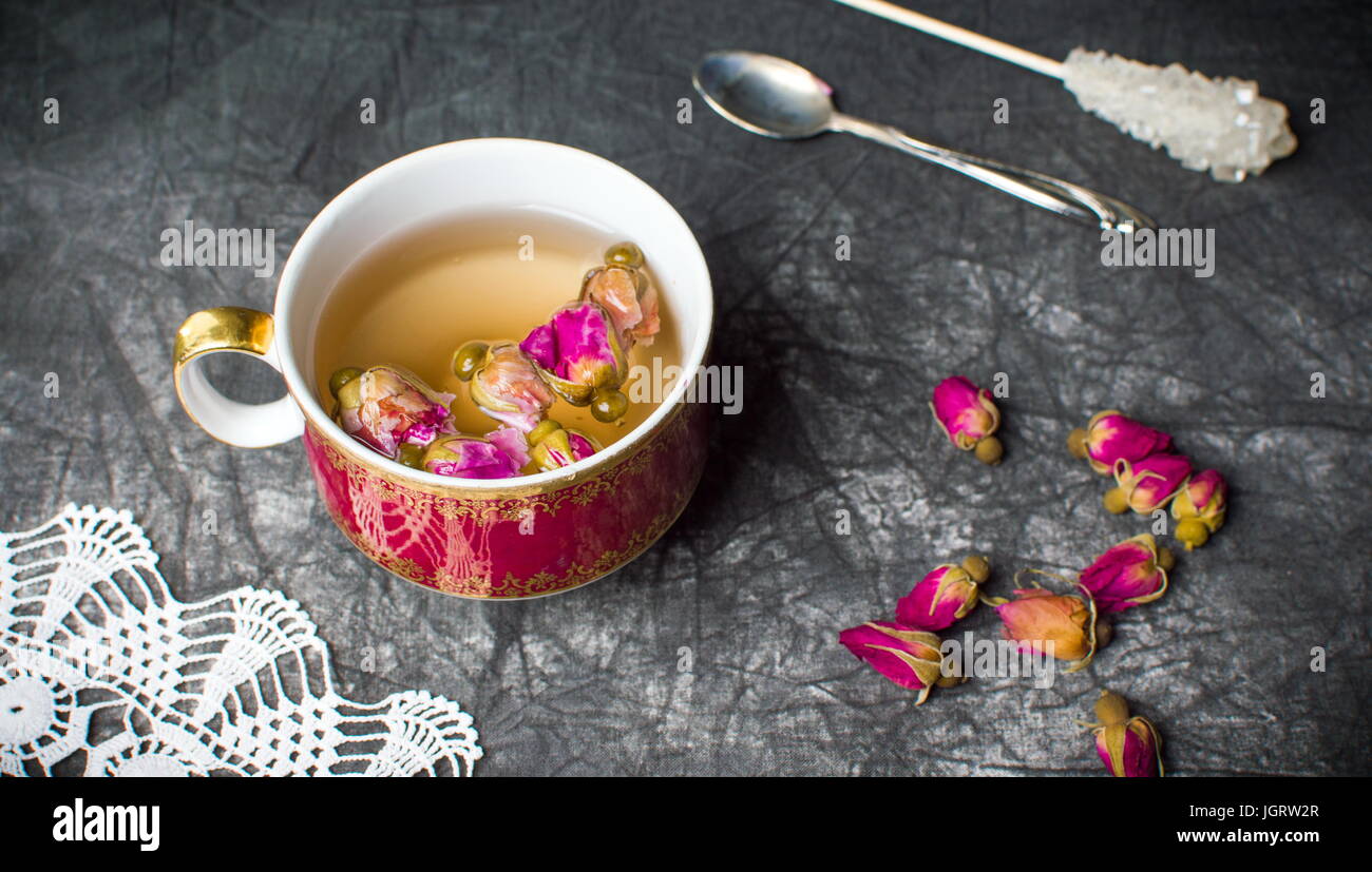 Plateau Rose en rouge tasse sur toile sombre Banque D'Images