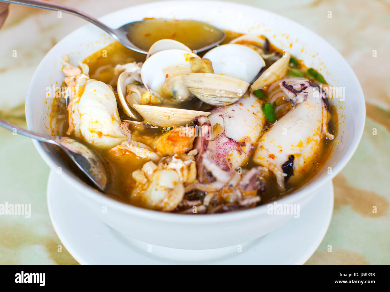 Fruits de mer, soupe Tom Yam Thai servi dans un bol blanc Banque D'Images