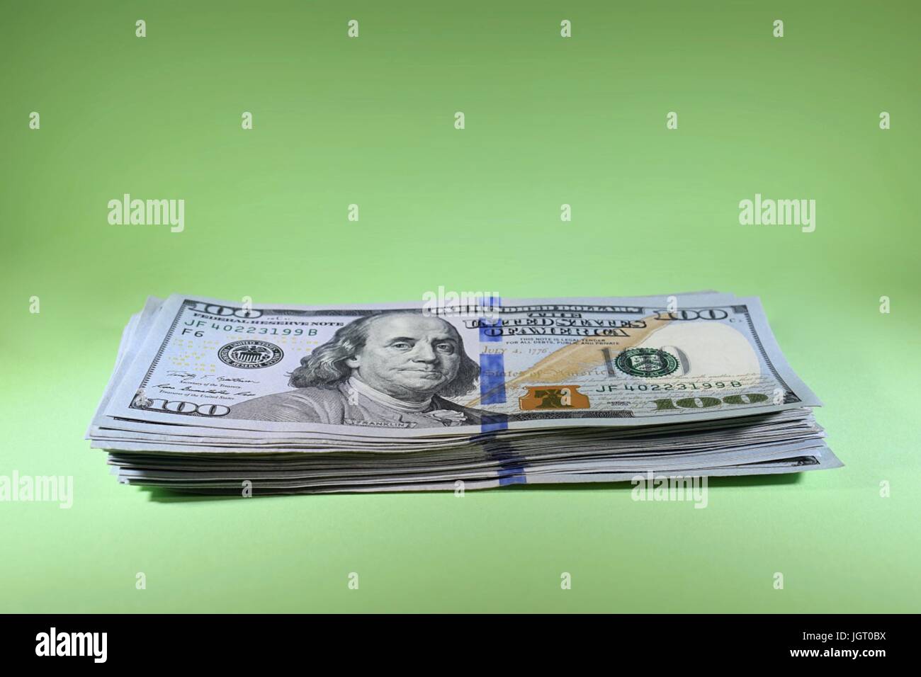 Pile unique de nouveaux billets de cent dollars américains 100 USD en argent comptant de l'argent sur fond vert Banque D'Images