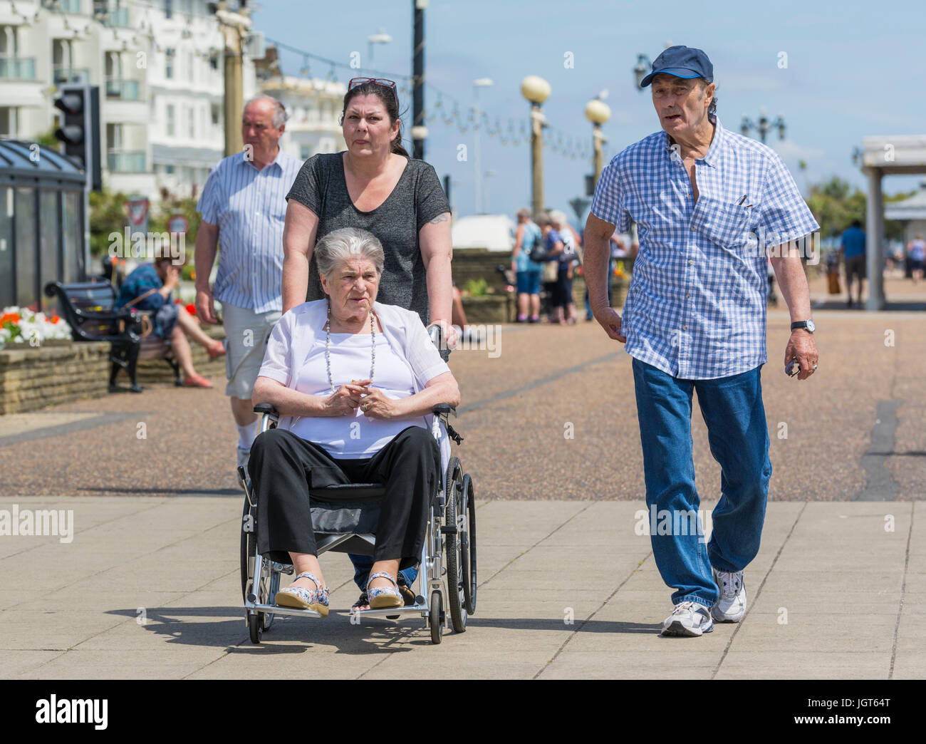 Femme âgées handicapées soit poussé dans un fauteuil roulant. Banque D'Images
