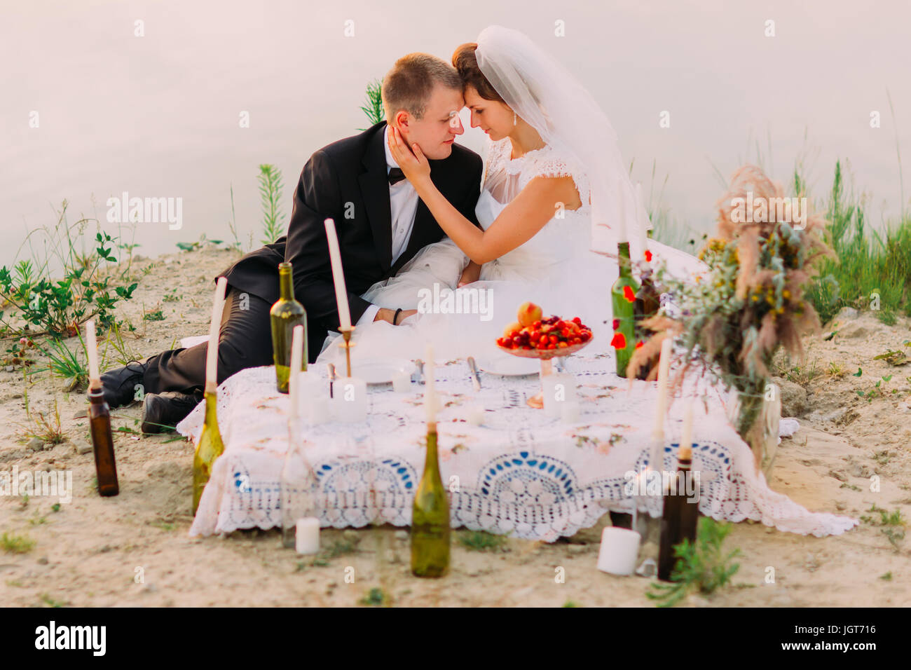 Les mariés sont assis près de la mariage pique-nique sur la plage. Banque D'Images