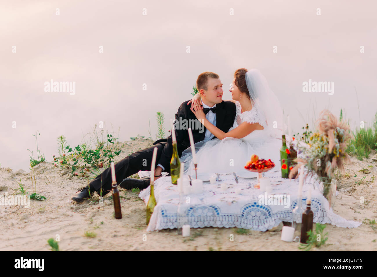 Le mariage pique-nique sur la côte de l'étreindre de nouveaux mariés. Banque D'Images