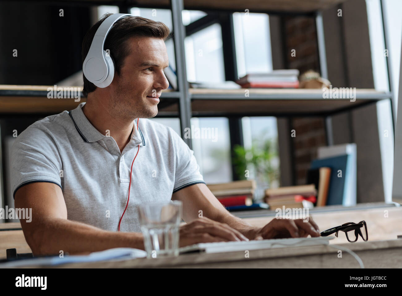 L'homme motivé créatif d'écouter de la musique sur son lieu de travail Banque D'Images