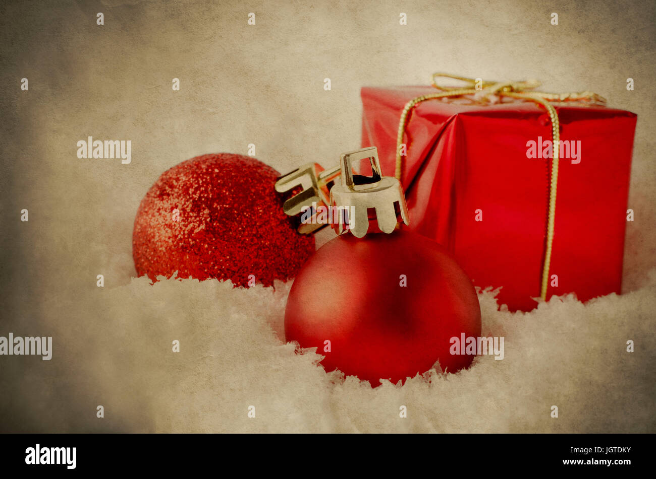 Un arrangement de décorations de Noël rouge sombre dans mou, blanc de la neige artificielle. Traitées pour donner une apparence, grunge, vintage. Banque D'Images