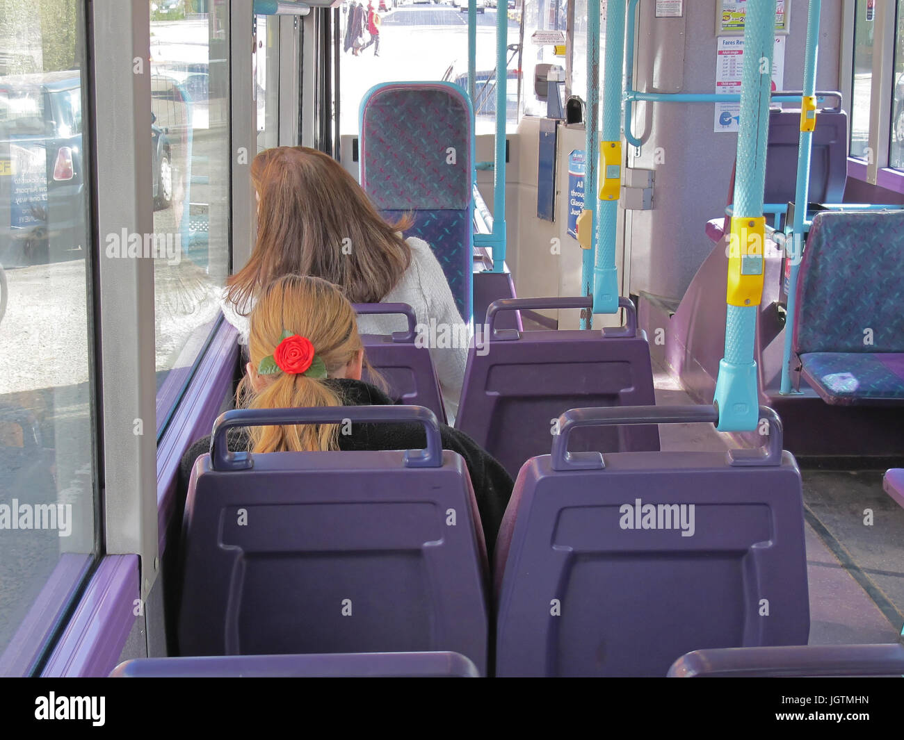 L'arrière de la tête avec un bandeau rose cheveux blonds fille femme sièges de transport public bus vide Banque D'Images