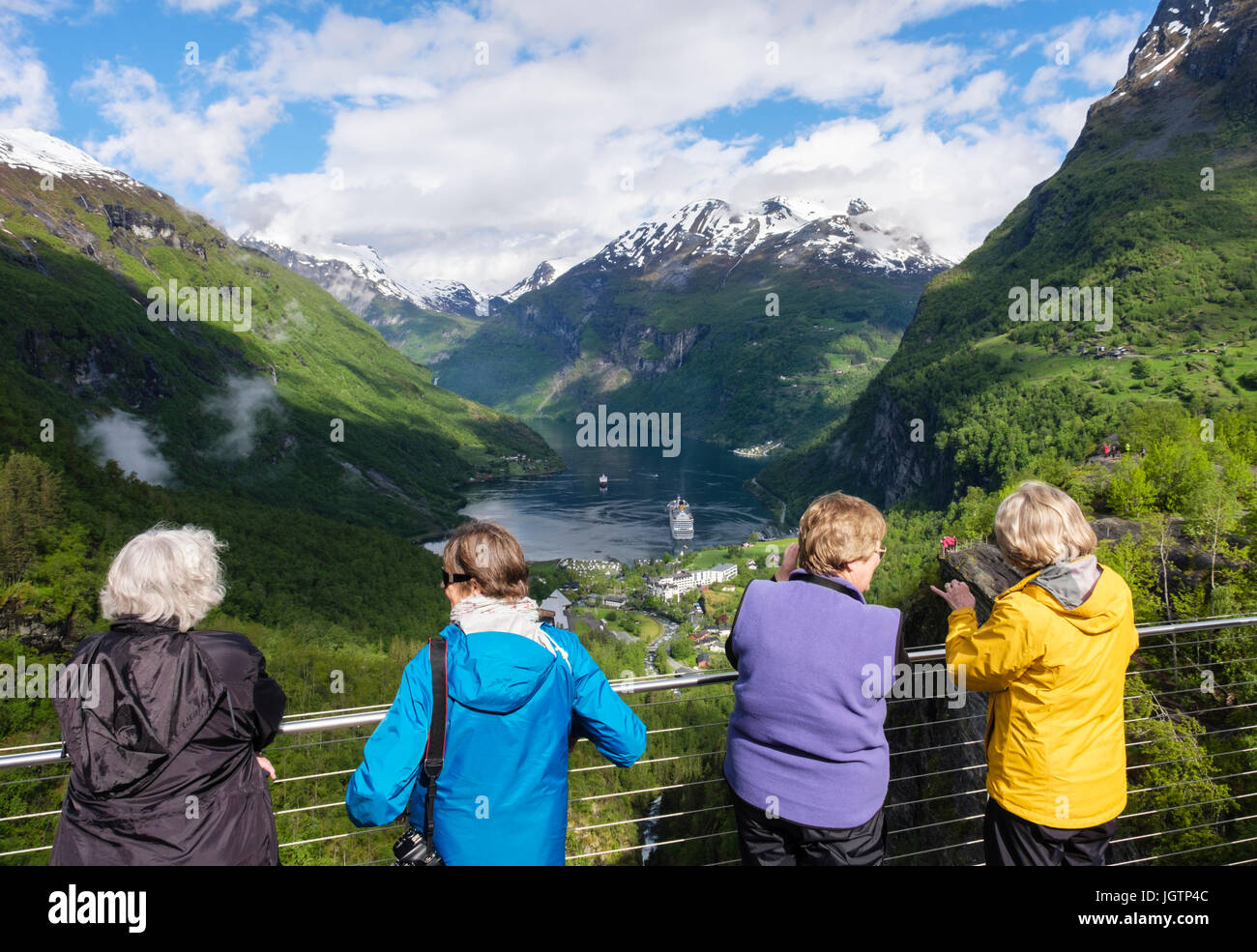 Quatre femmes à la recherche de touristes à vue panoramique à partir d'une vue surplombant le fjord Geirangerfjorden et village. Geiranger, comté de Møre og Romsdal (Norvège) Banque D'Images