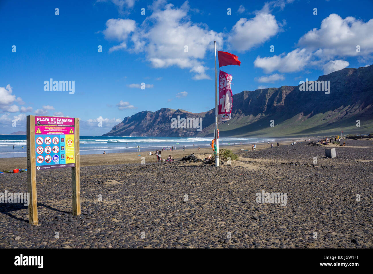 Drapeau rouge (baignade interdite) à la plage de Famara, derrière les montagnes de Famara, La Caleta de Famara, Lanzarote, îles Canaries, Espagne, Europe Banque D'Images