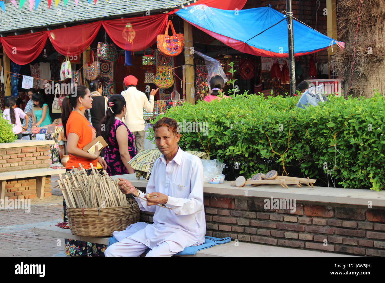 Homme jouant d'âge moyen, un Sarangi indien en bois instrument de musique pour attirer les clients à Dilli Haat, Pitampura, Delhi, Inde. Banque D'Images