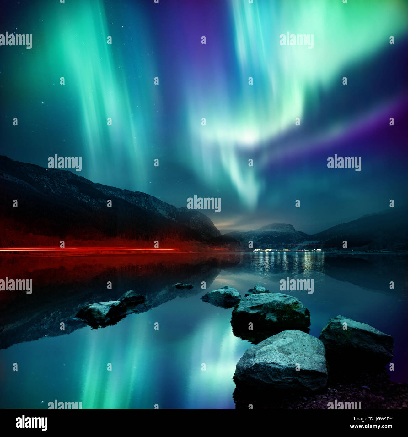 Un grand Northern Lights (aurores boréales) affichage plus lumineux un col et réfléchi sur un lac dans la nuit. La composition de la photo. Banque D'Images