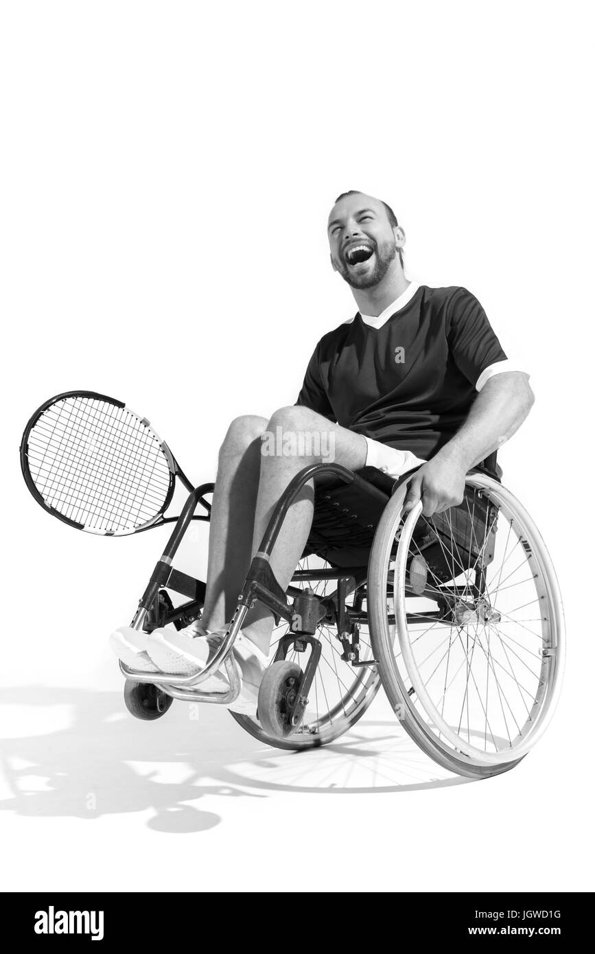 Photo en noir et blanc de l'heureux joueur de tennis en fauteuil roulant handicapés isolated on white Banque D'Images