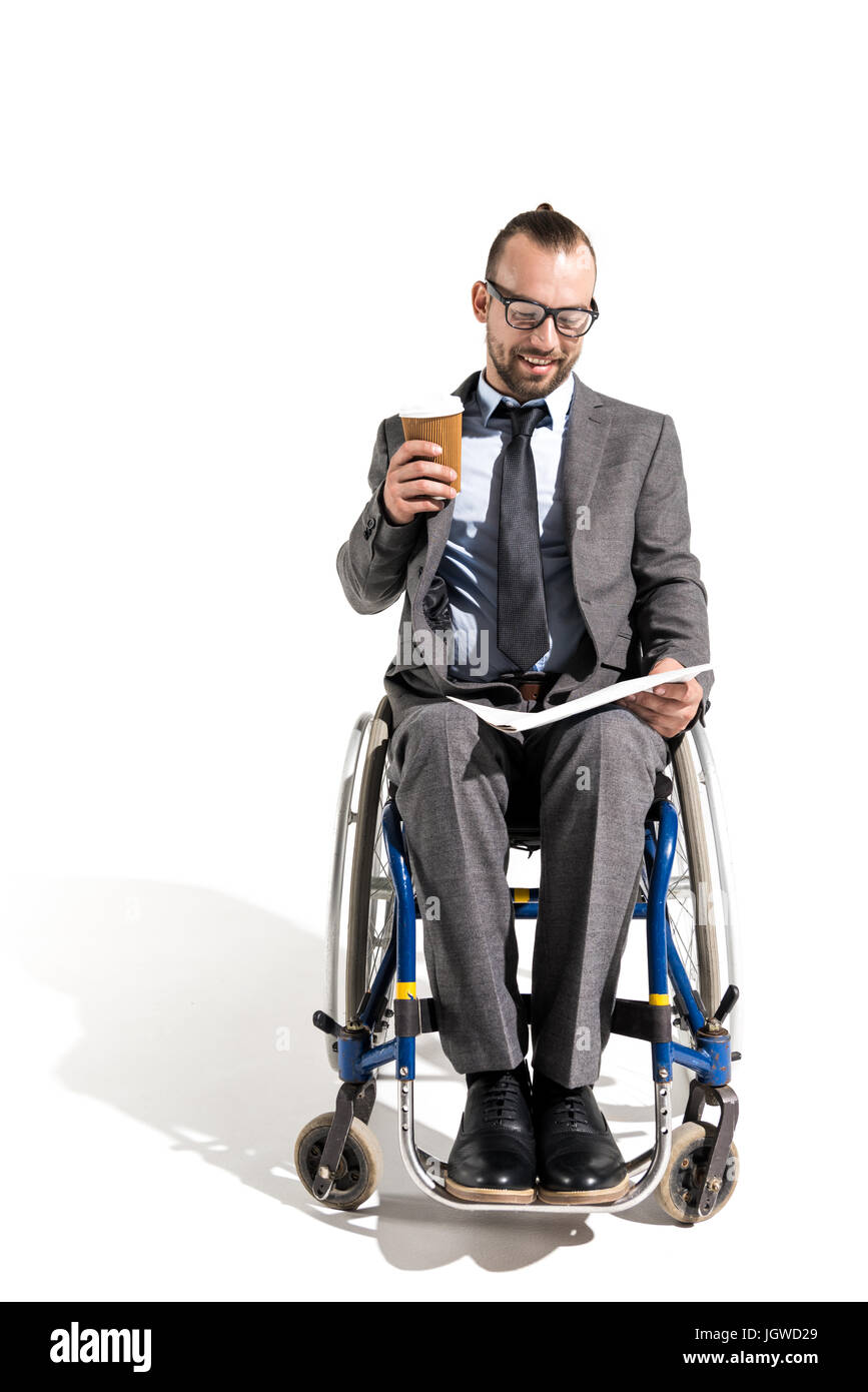 Man in wheelchair with pour reading newspaper isolated on white Banque D'Images