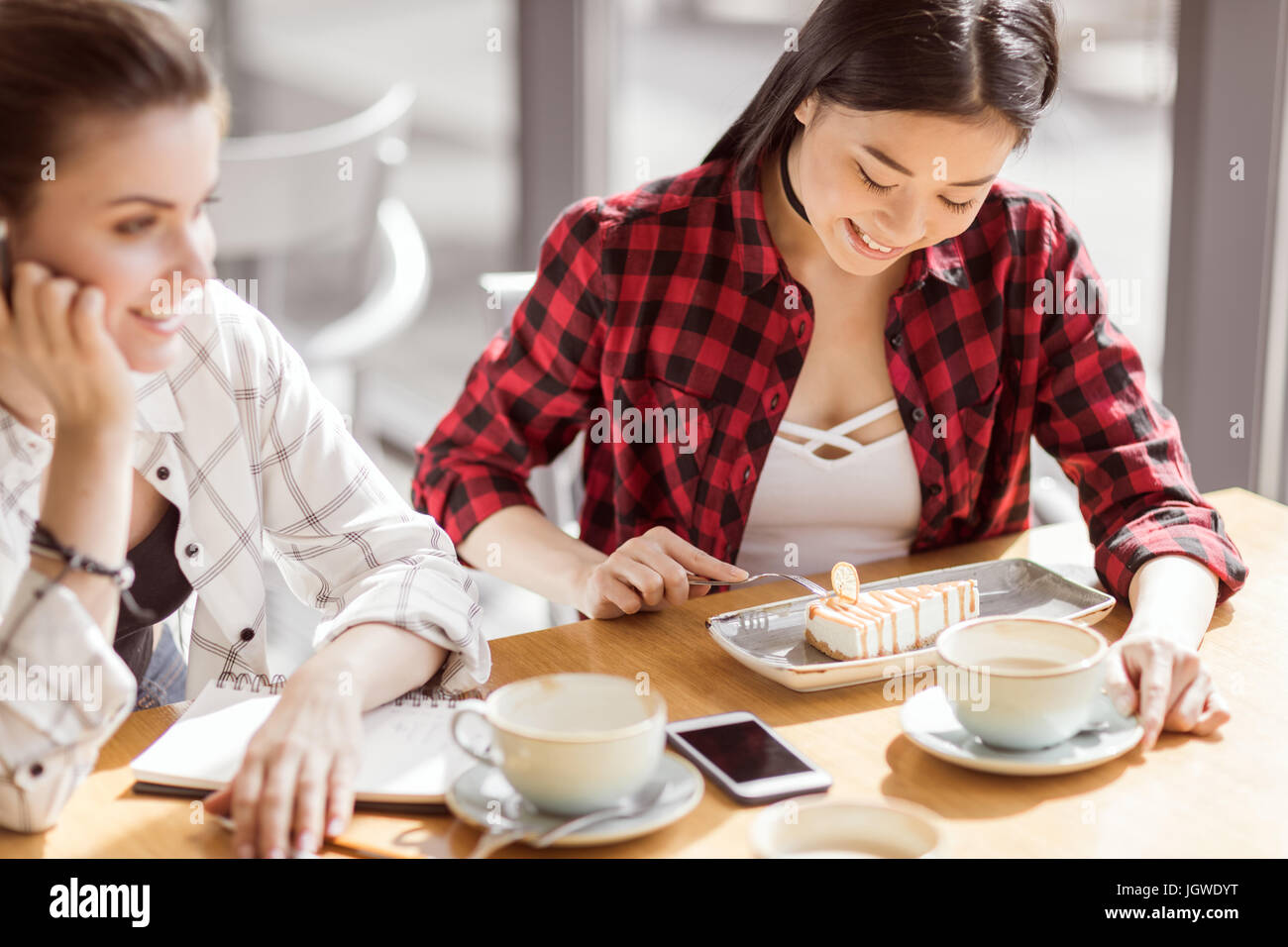 Les jeunes filles manger un gâteau et de boire du café au café, la pause-café Banque D'Images