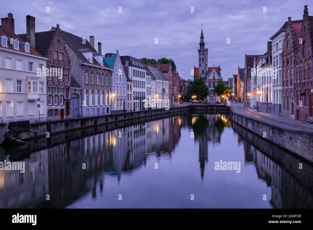Jan van Eyckplein, vieille ville de Bruges, Belgique pendant le coucher du soleil avec la réflexion sur l'eau. Banque D'Images