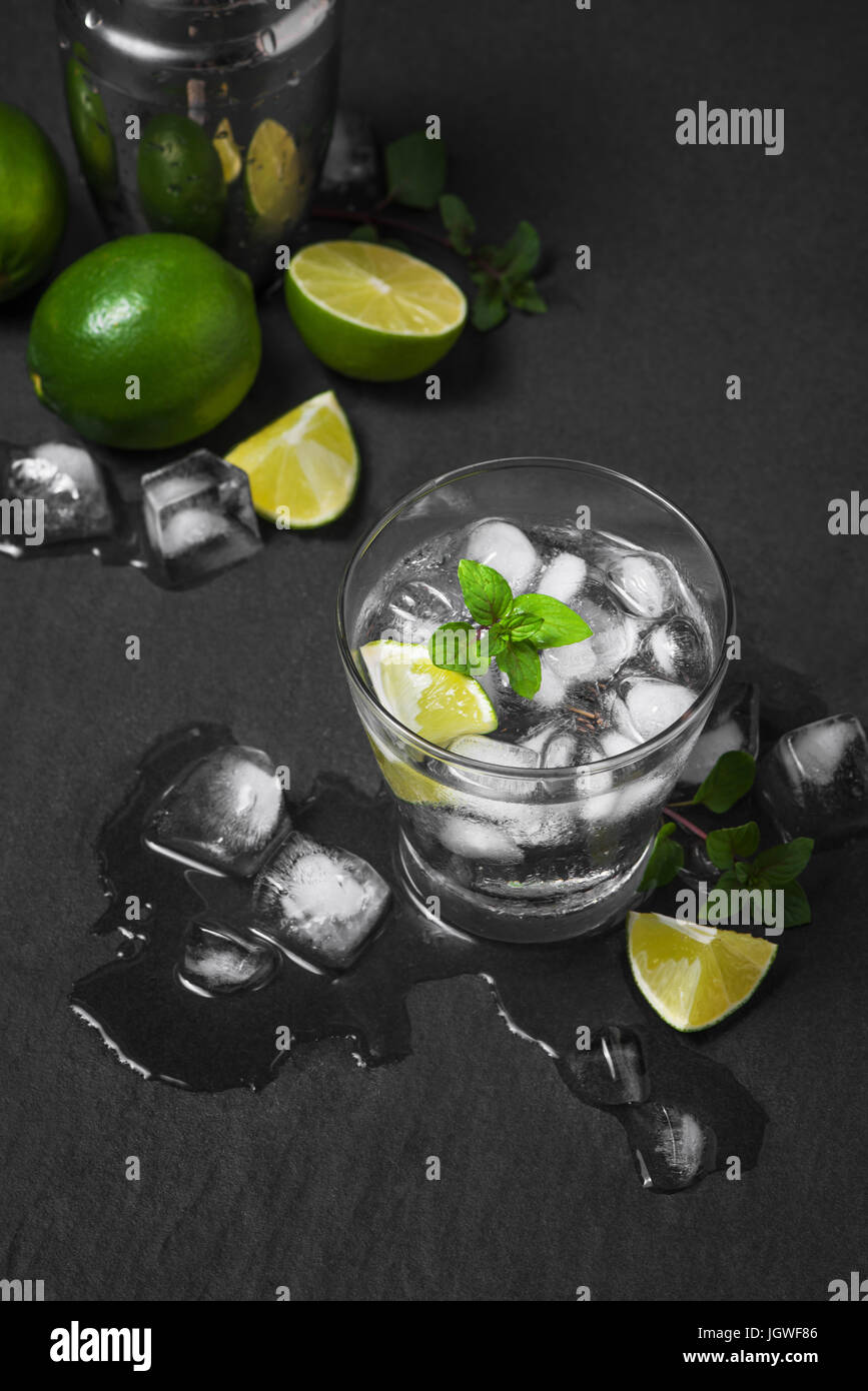 Mojito cocktail avec de la chaux et de menthe dans le verre sur un fond noir en gris Banque D'Images