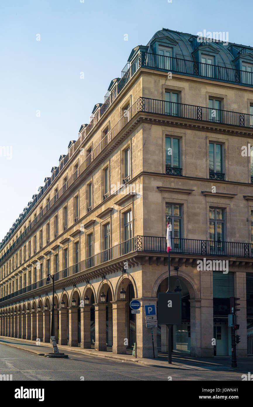 Un bâtiment de style typiquement Haussmann à Paris avec balcons, arcades et boutiques sous une lumière chaude de fin d'après-midi. Banque D'Images