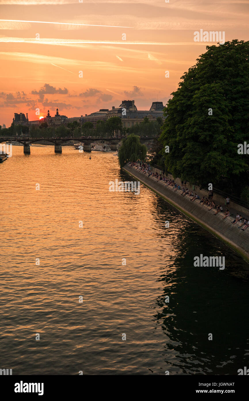 Coucher de soleil sur le centre historique de Paris avec la Seine et ses quais à l'avant-plan. Banque D'Images