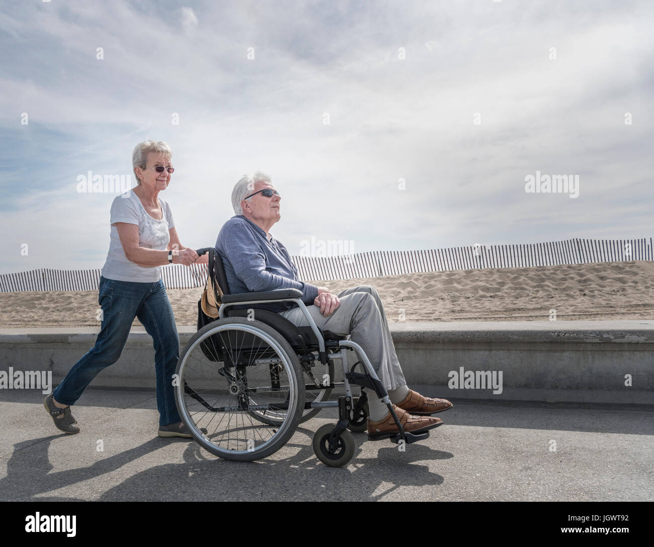 Hauts femme mari poussant en fauteuil roulant à Beach, Santa Monica, Californie, USA Banque D'Images