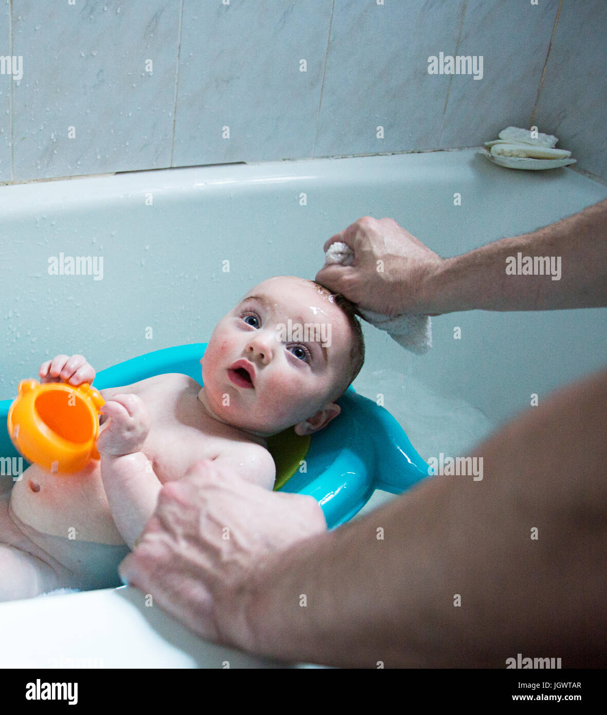 Les mains de père en fils bébé bain Baignoire bébé Banque D'Images