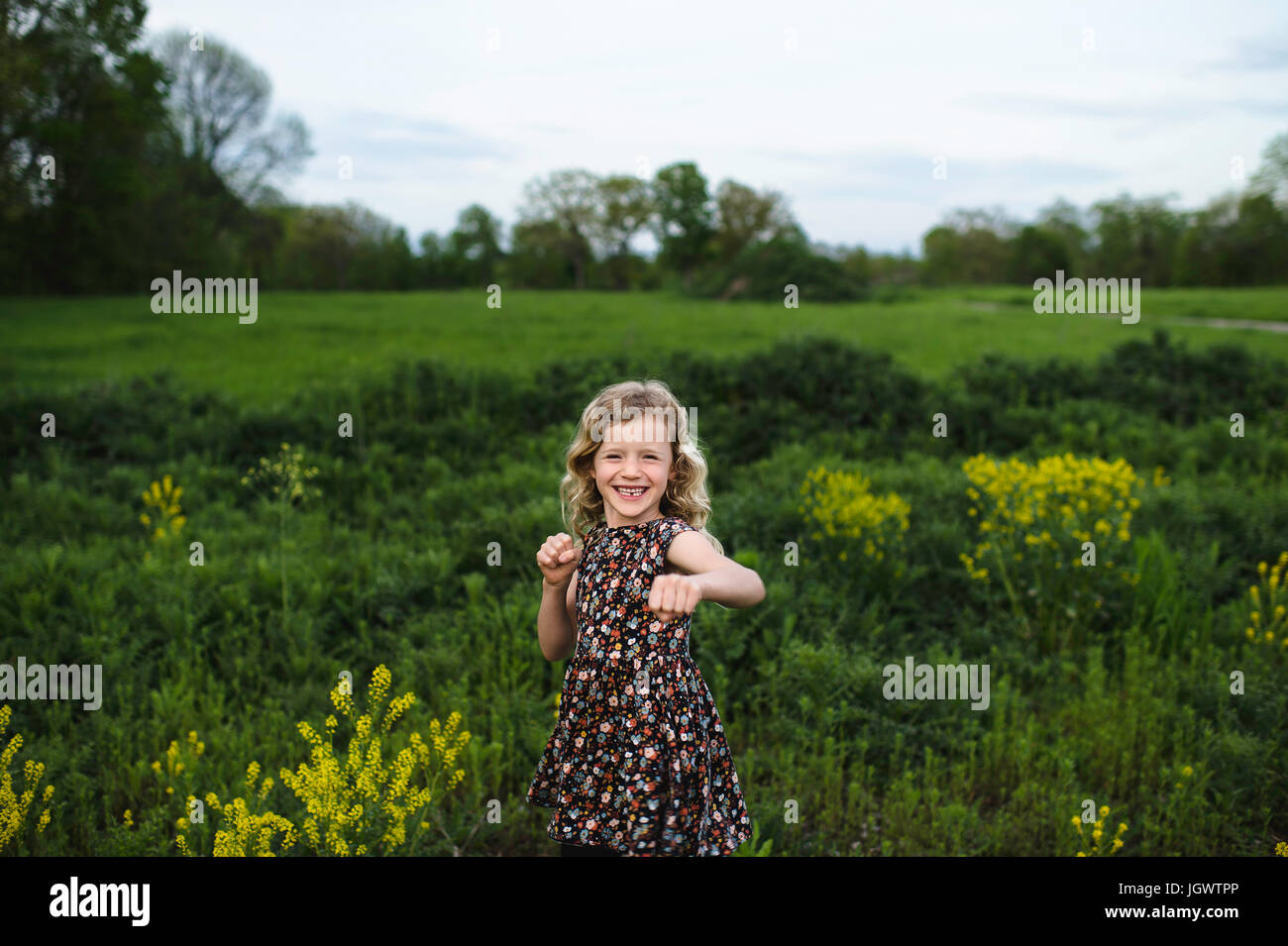 Portrait de jeune fille avec les cheveux blonds ondulés dans le champ de frappe Banque D'Images
