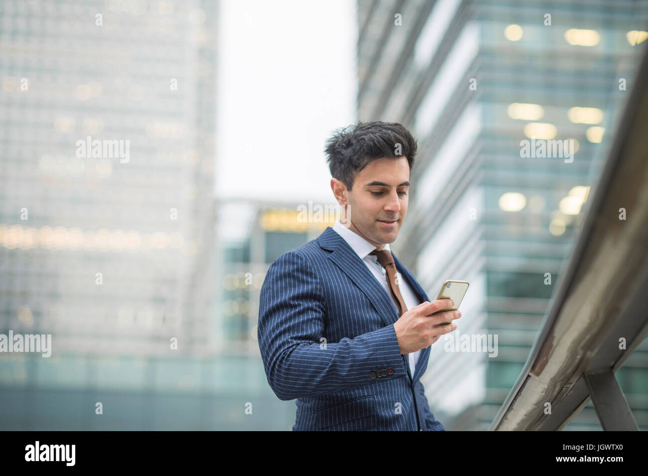 Businessman using mobile phone, Canary Wharf, London, UK Banque D'Images