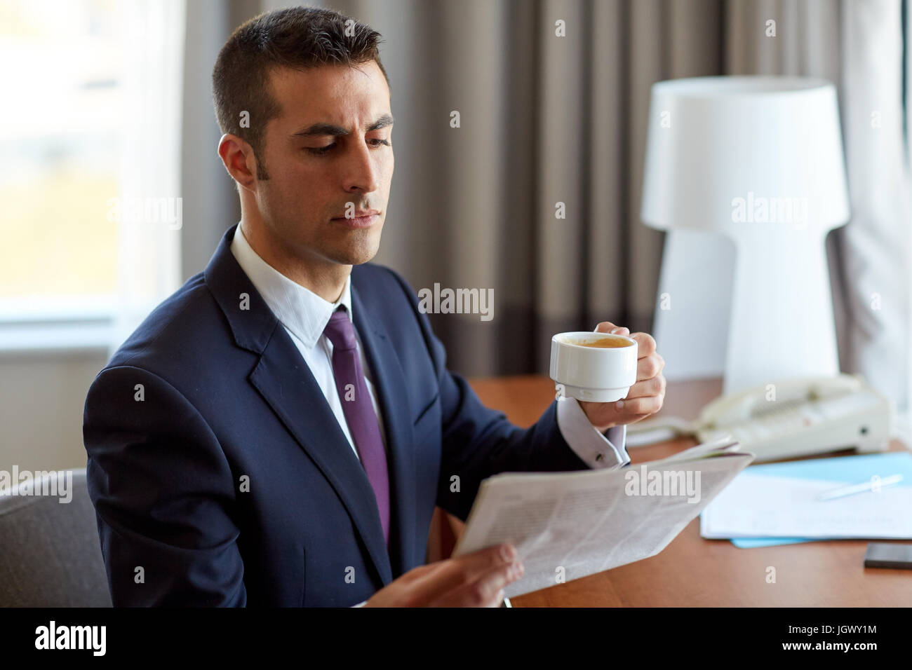 Businessman reading newspaper et boire du café Banque D'Images