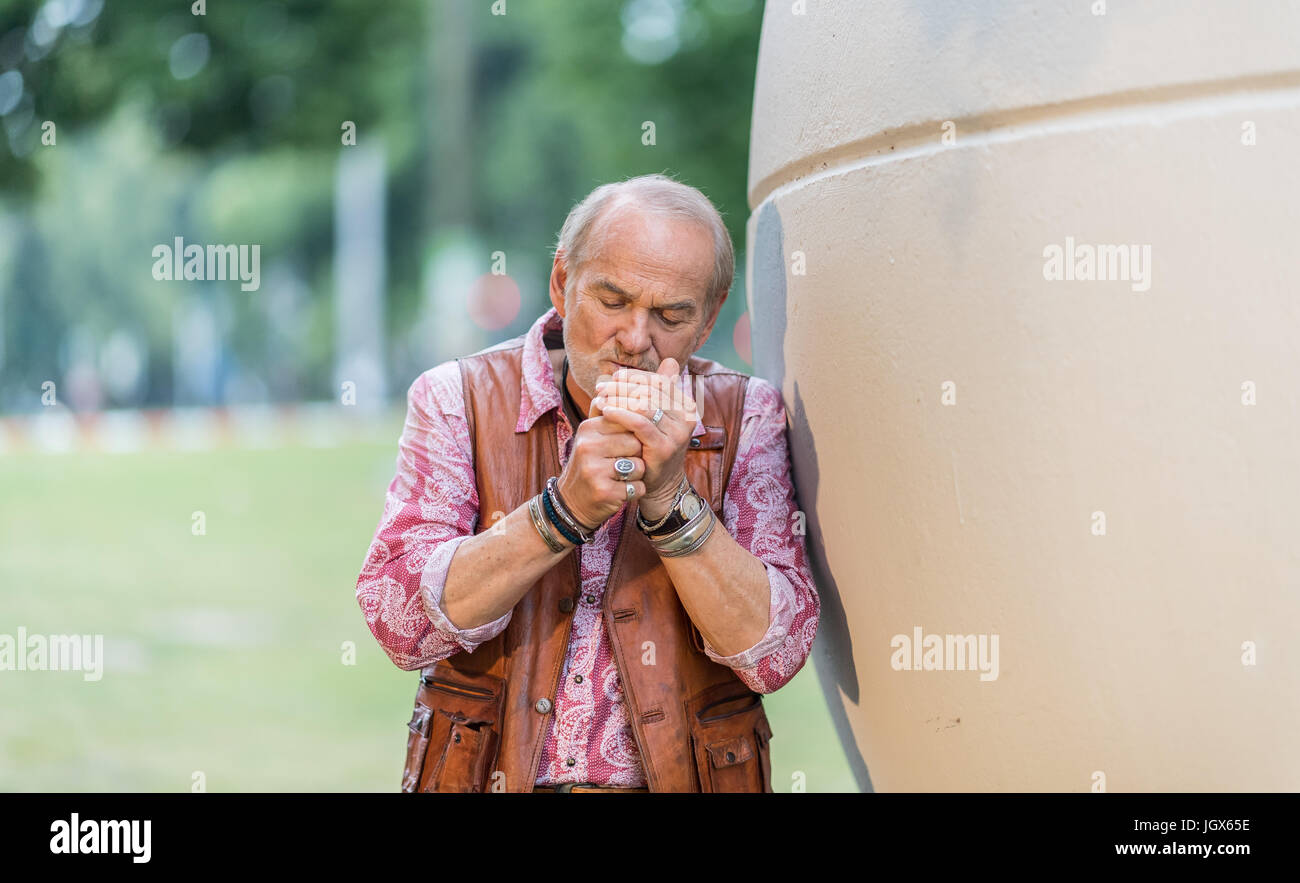 munster allemagne 29 juin 2017 claus dieter clausnitzer acteur herbert vaddern thiel dans le detective allemand tv show tatort allume un cigarillo a cote d une sculpture d une balle dans la piscine