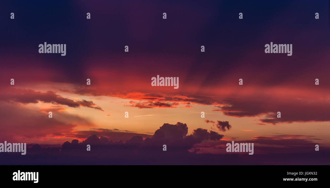 Rayons de soleil venant de la lumière à travers le trou dans les nuages de tempête pourpre Banque D'Images