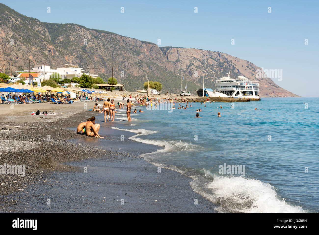 Plage de sable noir et gris d'Agia Roumeli, sur la côte sud de l'ouest de la Crète, Grèce. La petite ville est accessible uniquement par bateau ou à pied. Banque D'Images