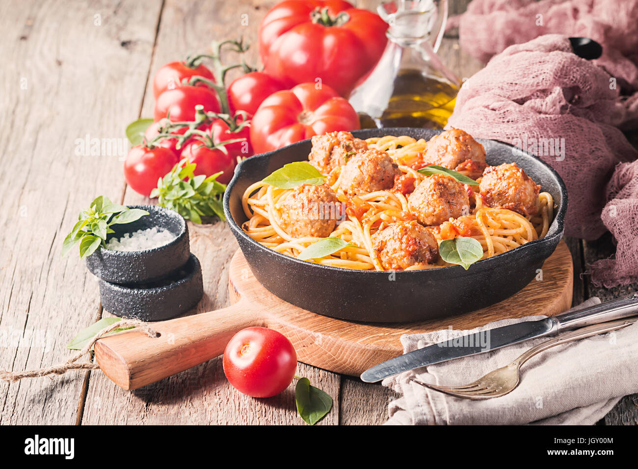 Les pâtes Spaghetti aux Boulettes de viande et de la sauce tomate dans la poêle en fonte sur fond de bois, Close up Banque D'Images