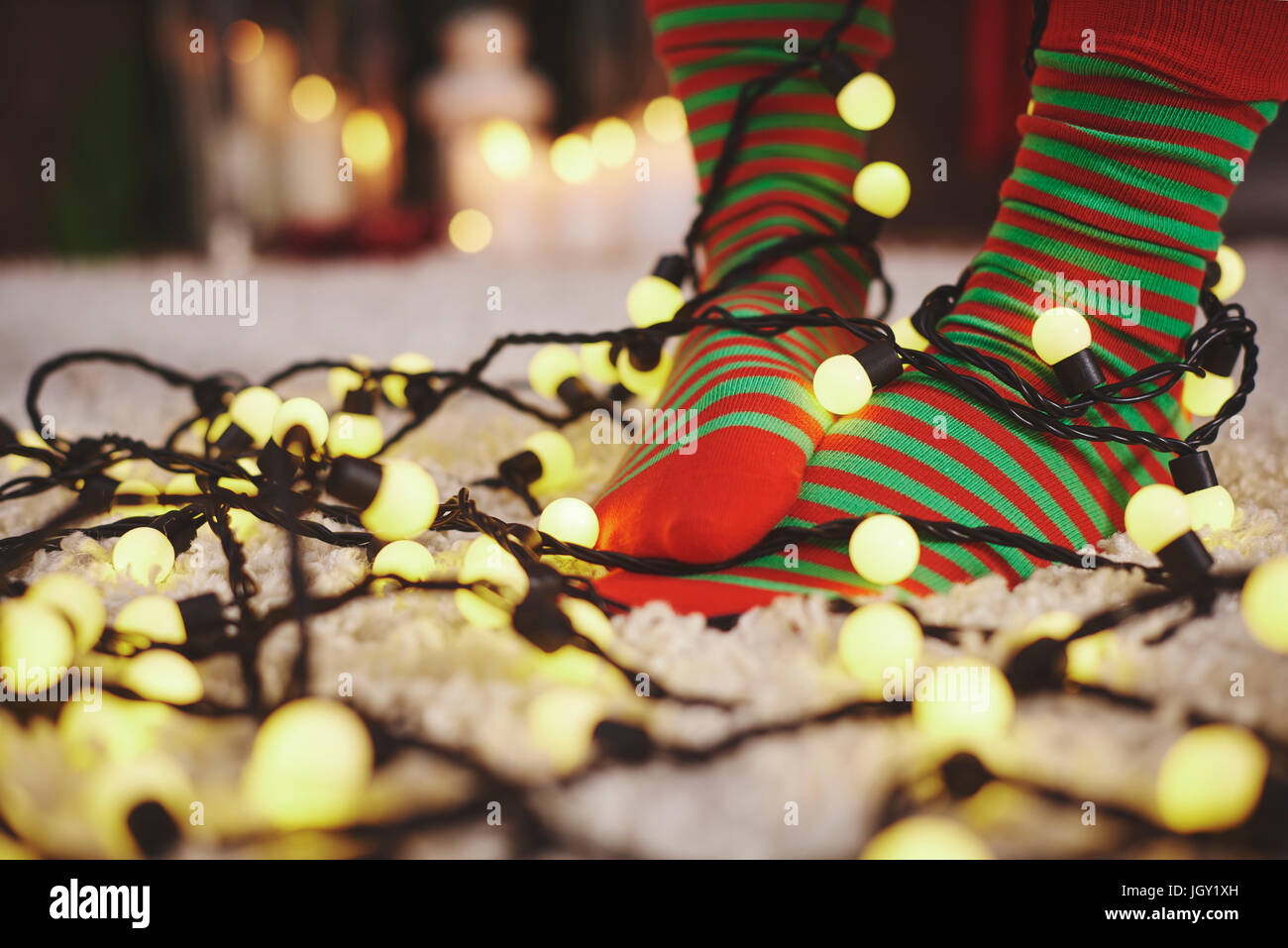 Pieds de femme portant des chaussettes à rayures enchevêtré dans fairy lights Banque D'Images