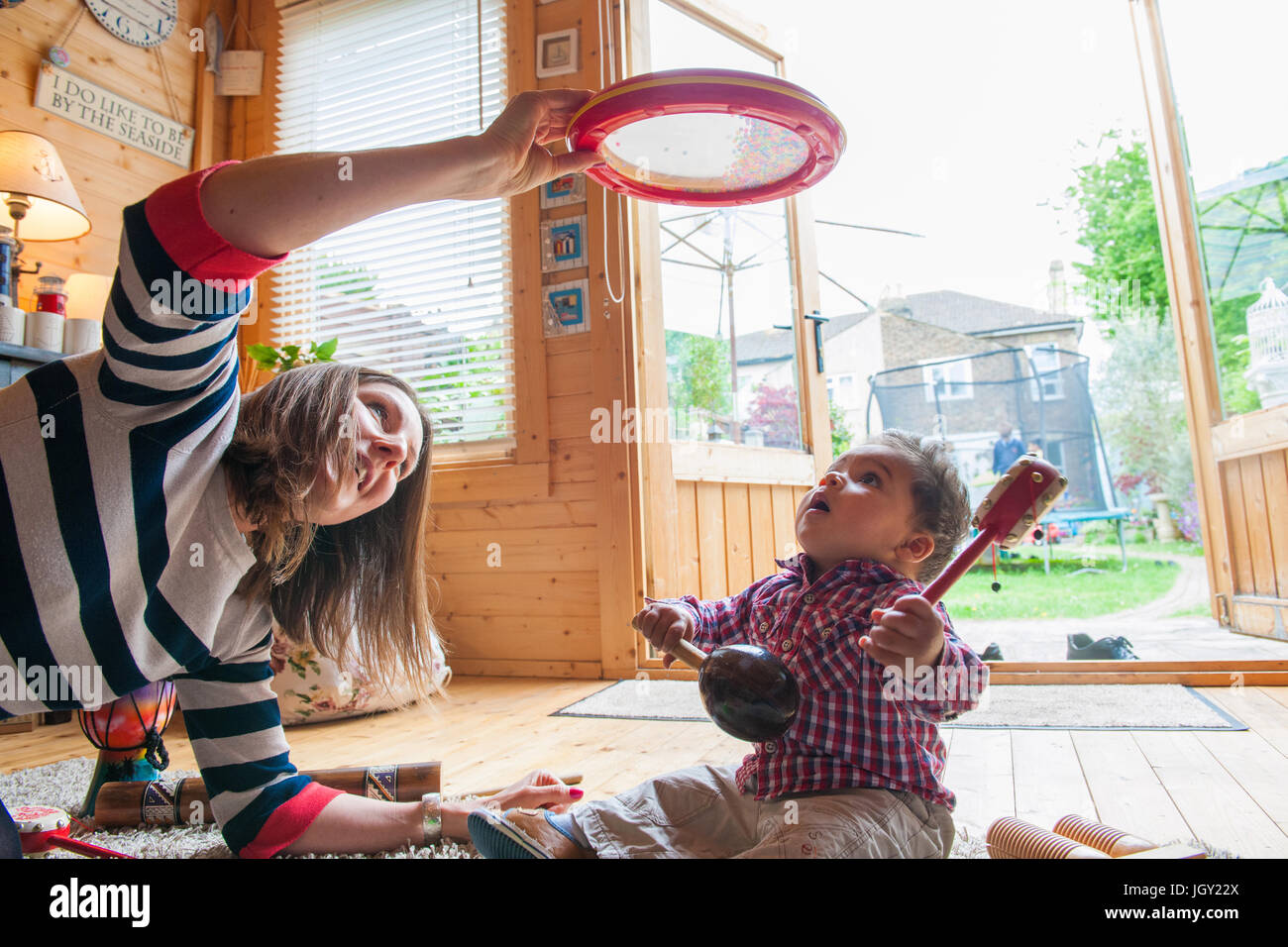 Nourrice et Bébé Garçon jouant avec tambourin Banque D'Images