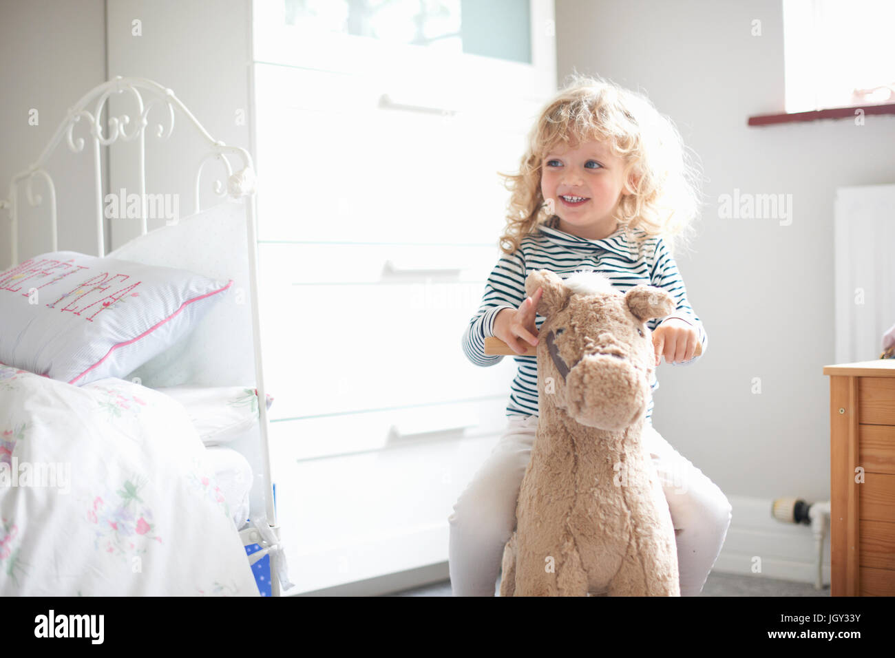 Petite fille à cheval à bascule dans la chambre Banque D'Images