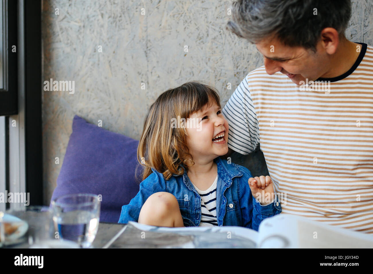 Girl rire avec père in cafe Banque D'Images