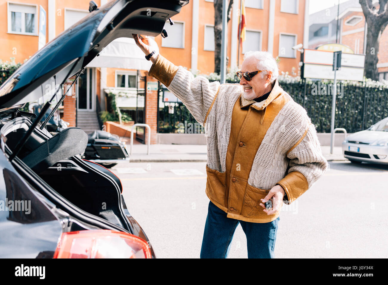 Man holding up porte coffre de voiture, Milan, Italie Banque D'Images