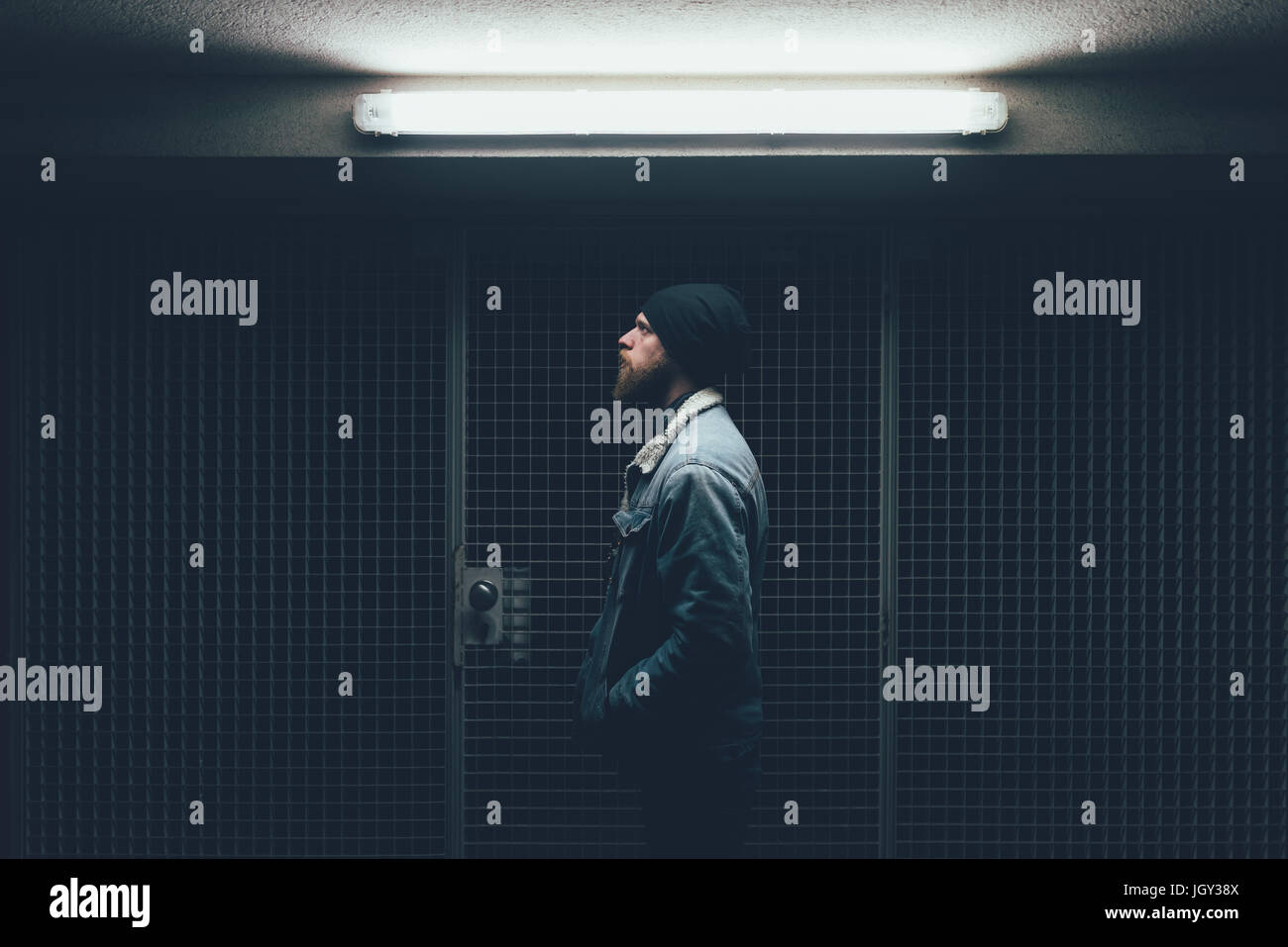 Jeune homme hipster dans Dark city porte à nuit Banque D'Images