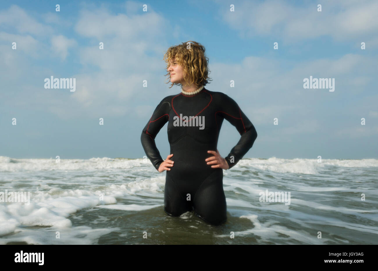 Fille debout dans la mer du Nord wearing wetsuit Banque D'Images
