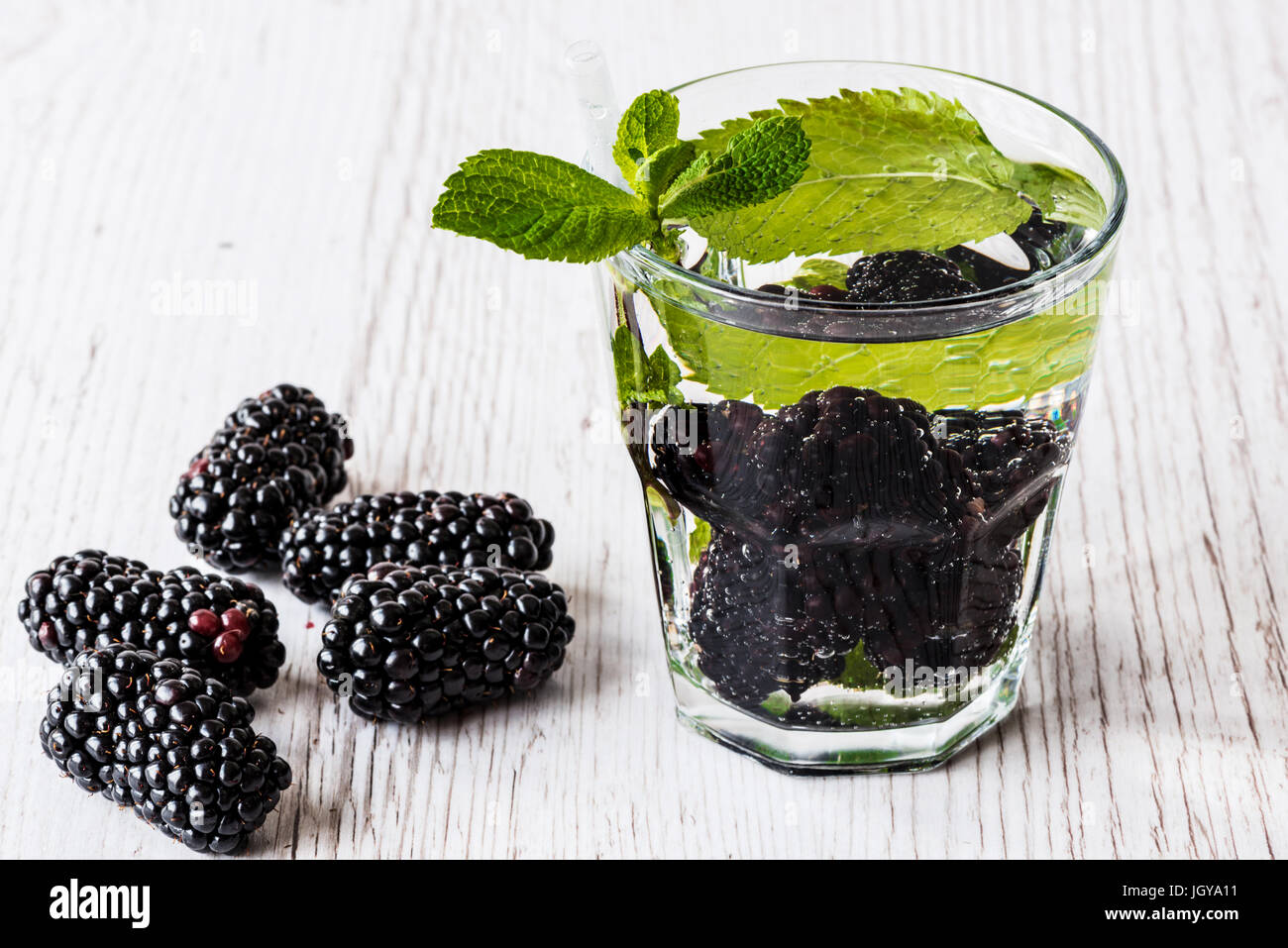 L'eau detox avec blackberry et de menthe dans le verre on white background. Banque D'Images