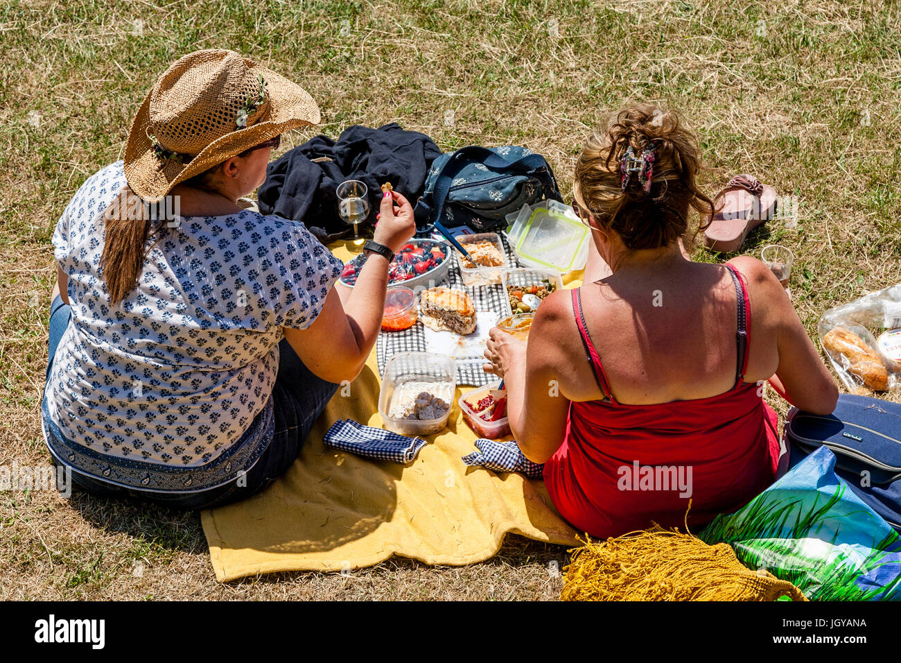 Deux femmes assises sur les rives de la rivière Ouse bénéficiant d''un pique-nique, Lewes, dans le Sussex, UK Banque D'Images